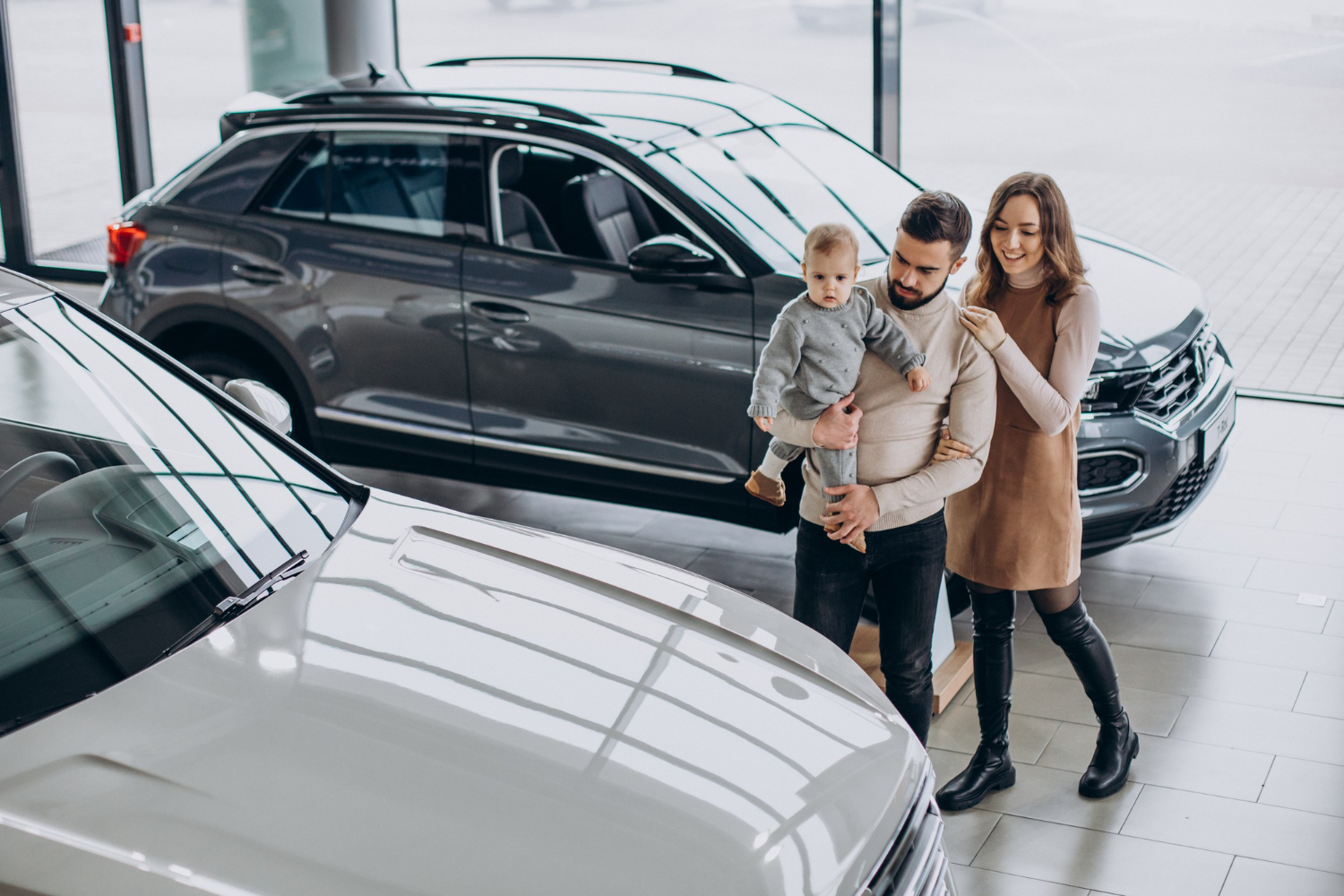 familia-nina-pequena-eligiendo-coche-sala-exposicion-coches